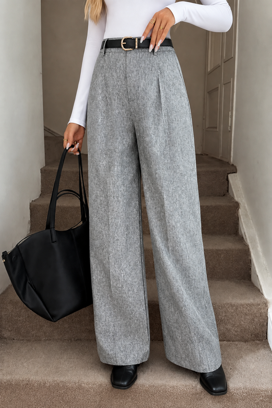 Grey wide-leg pants styled with a white shirt and black boots