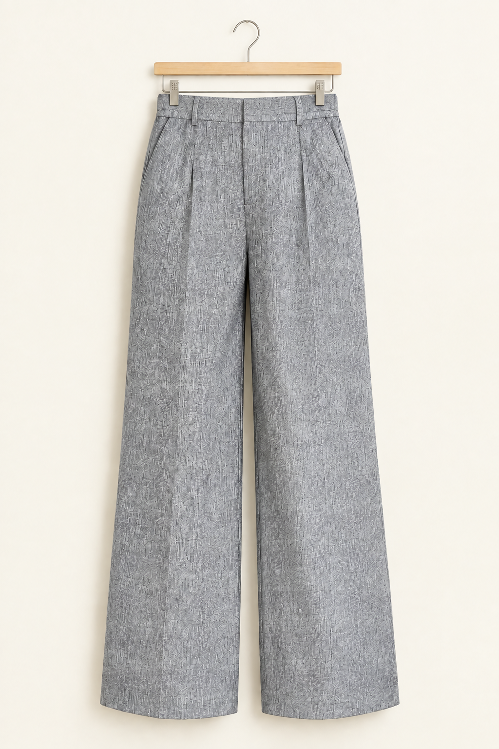 Grey wide-leg dress pants displayed on a wooden hanger