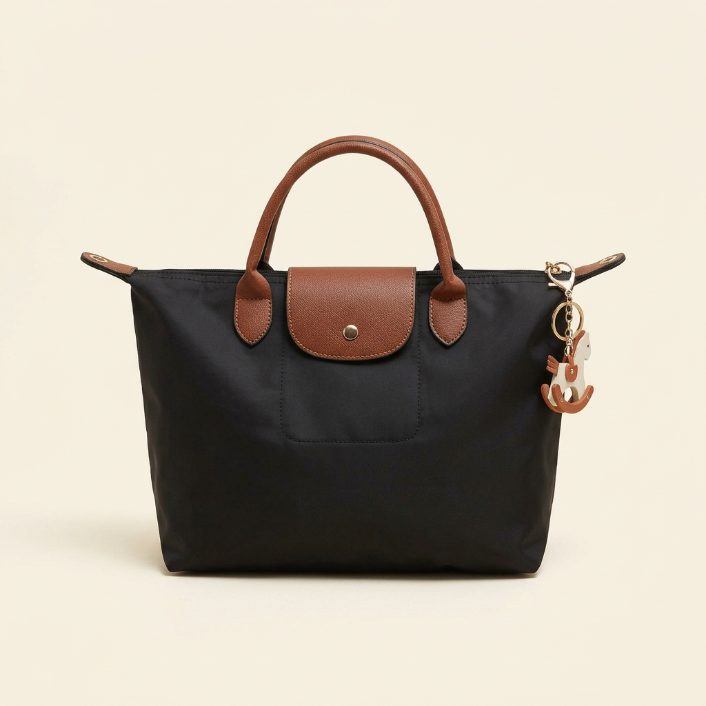 Black nylon tote with brown handles and flap on a plain ivory background