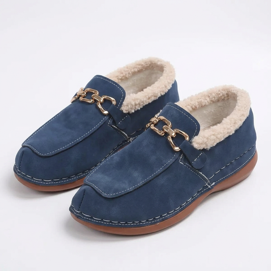 Blue fluffy-lined loafers with gold-tone chain details on a plain white background