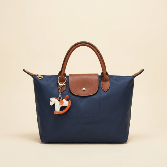 Navy blue nylon tote with brown handles and flap on a plain ivory background