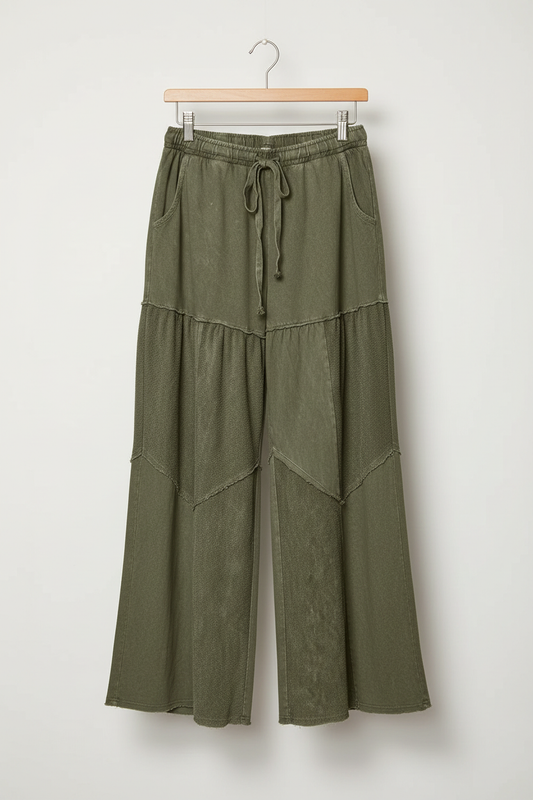 Sage tiered wide-leg pants on a wooden hanger