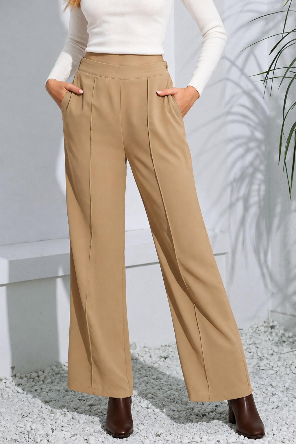 Tan pants styled with a white sweater and ankle boots